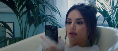 a woman in a bathtub holding a cell phone