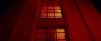 a red light shining through a window of a building