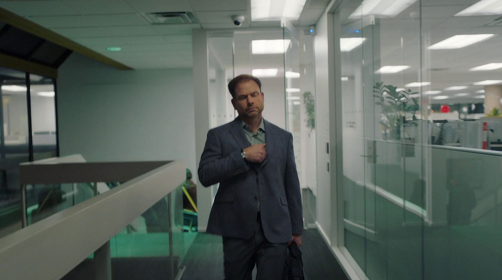 a man in a suit standing in a hallway