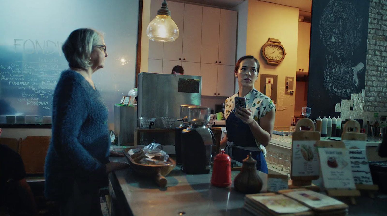 a woman standing in a kitchen next to another woman