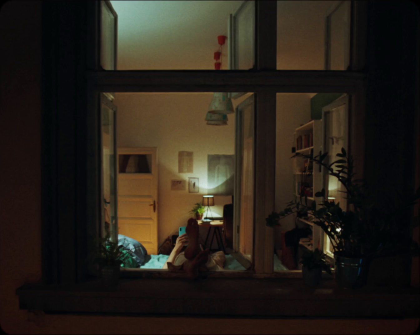 a person sitting on a window sill at night