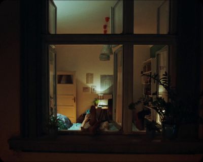 a person sitting on a window sill at night