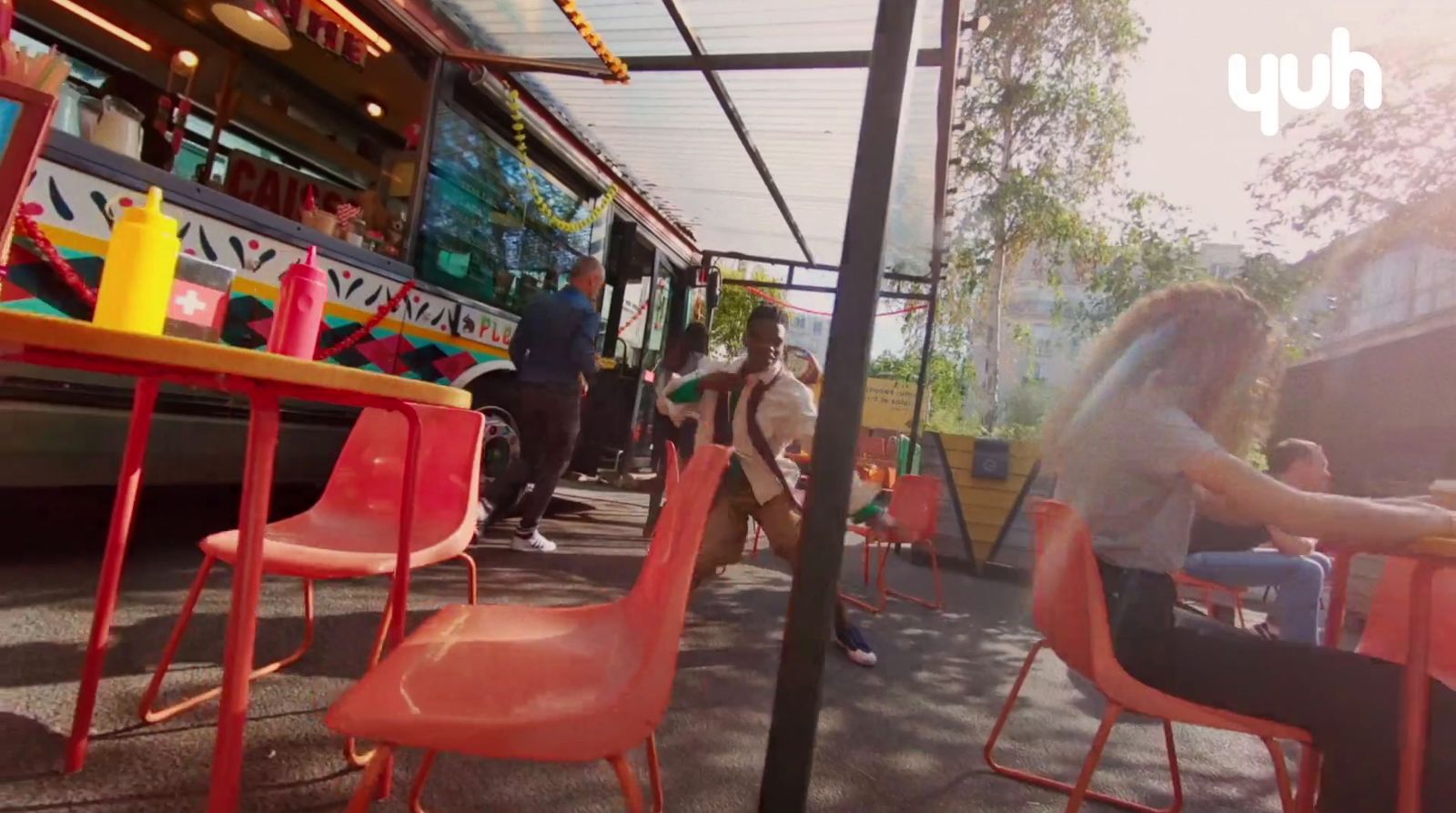 a group of people sitting at a table in front of a bus