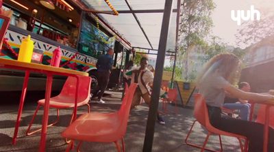 a group of people sitting at a table in front of a bus