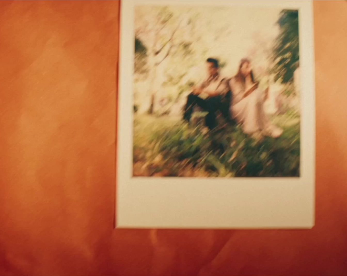 a polaroid picture of a couple sitting on a bench