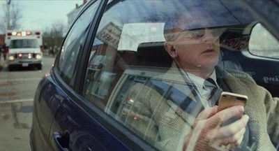 a man sitting in a car holding a cell phone