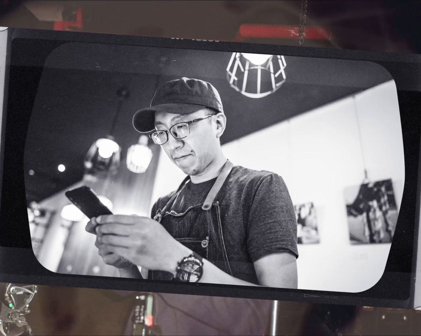 a black and white photo of a man holding a cell phone