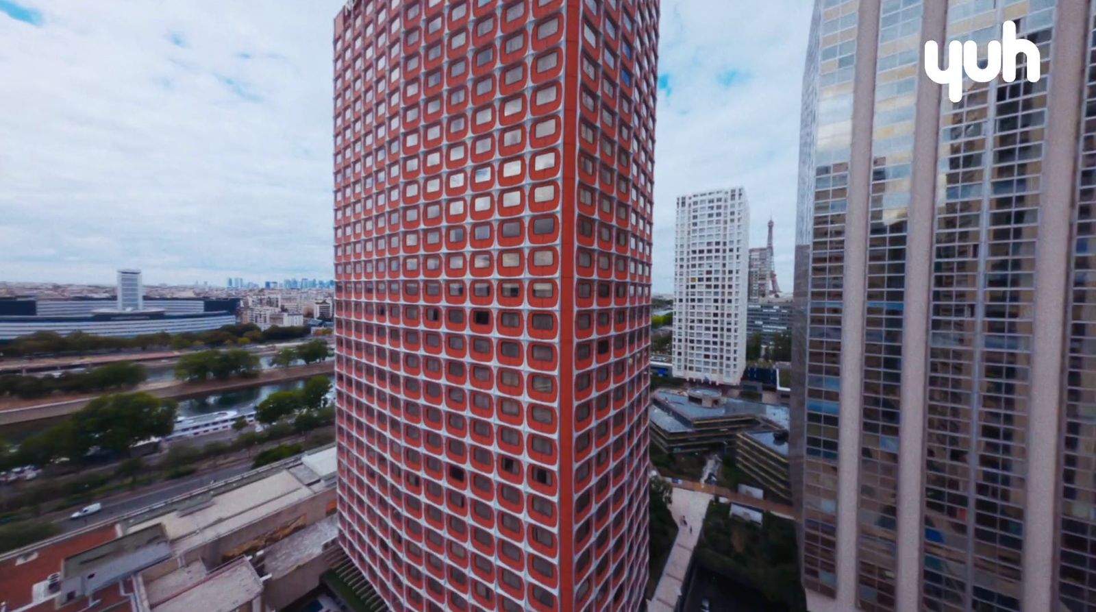 a very tall red building in the middle of a city