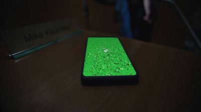 a green cell phone sitting on top of a wooden table