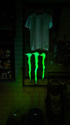 a neon green monster logo glows in the dark