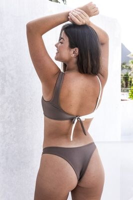 a woman in a bikini standing next to a wall