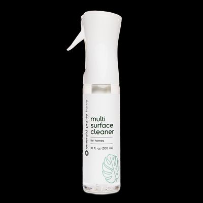 a bottle of multi surface cleaner on a black background