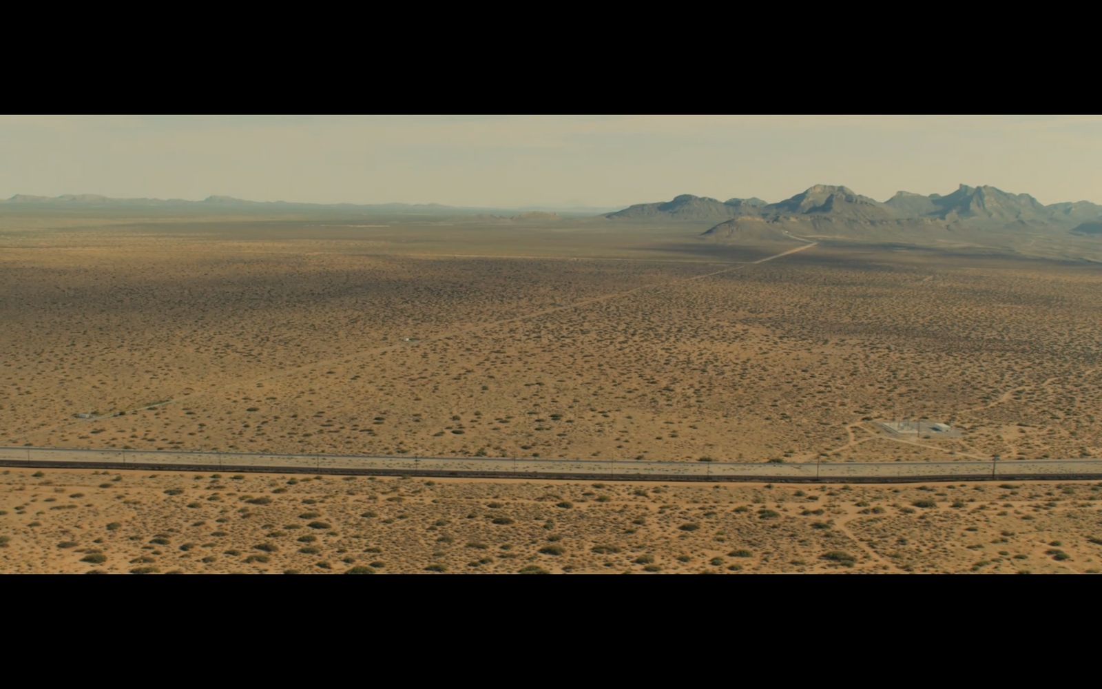 an aerial view of a road in the middle of the desert