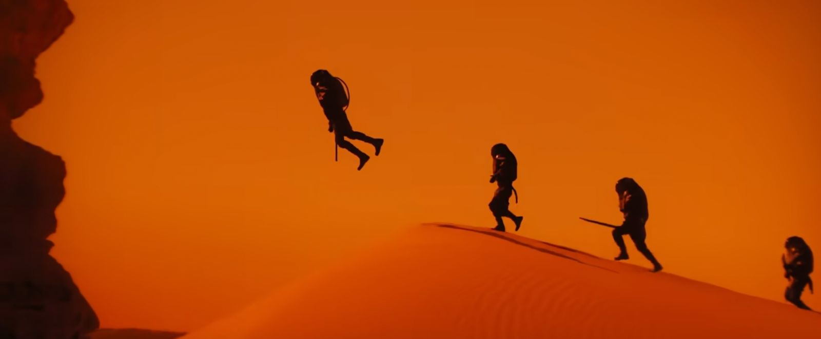 a group of people walking across a desert