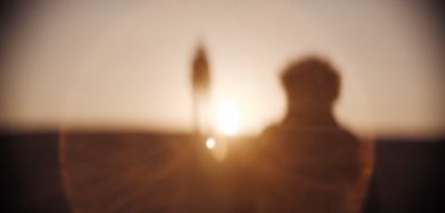 a blurry photo of a person standing in front of the sun