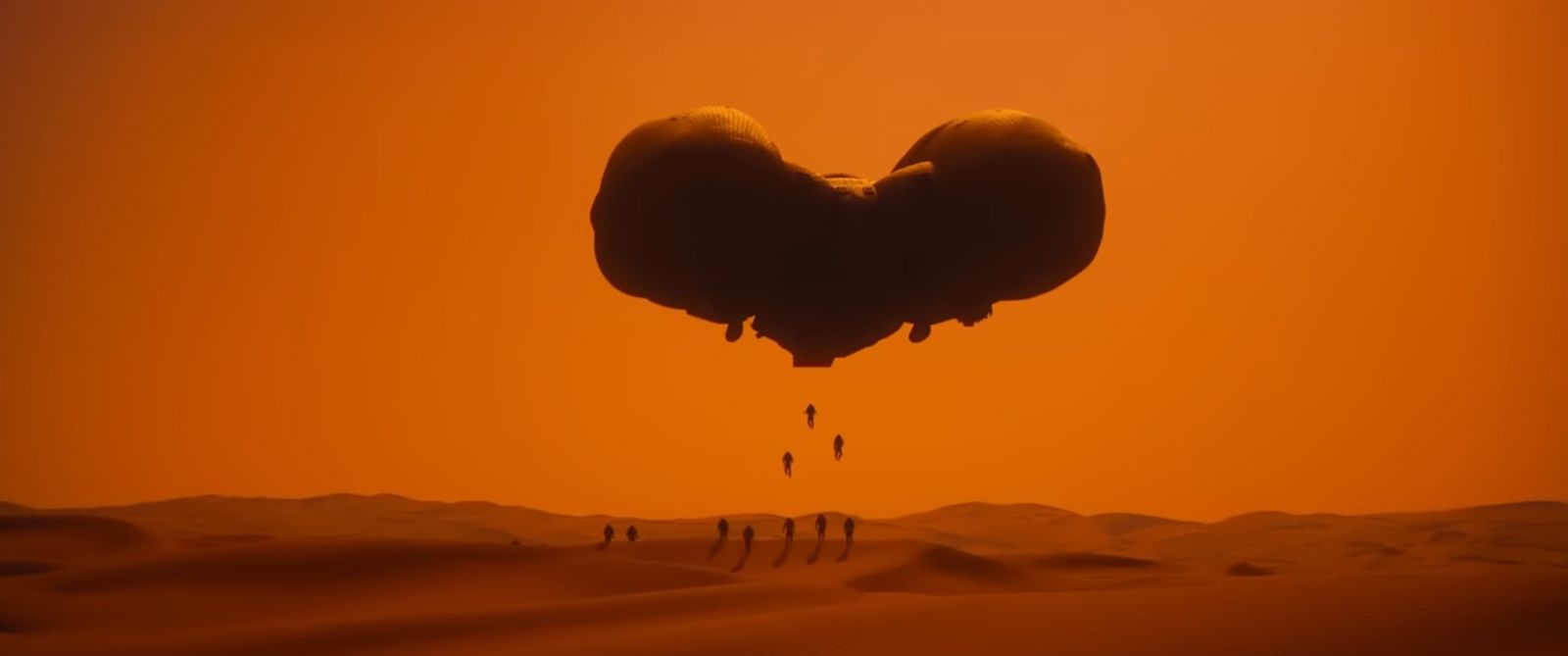 a large object flying through the air over a desert