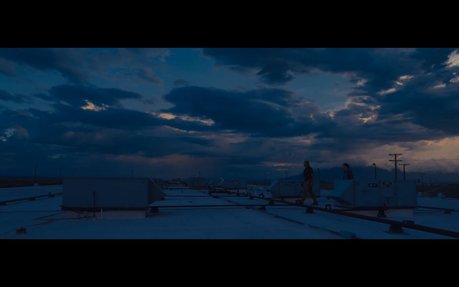 a man standing on top of a roof under a cloudy sky