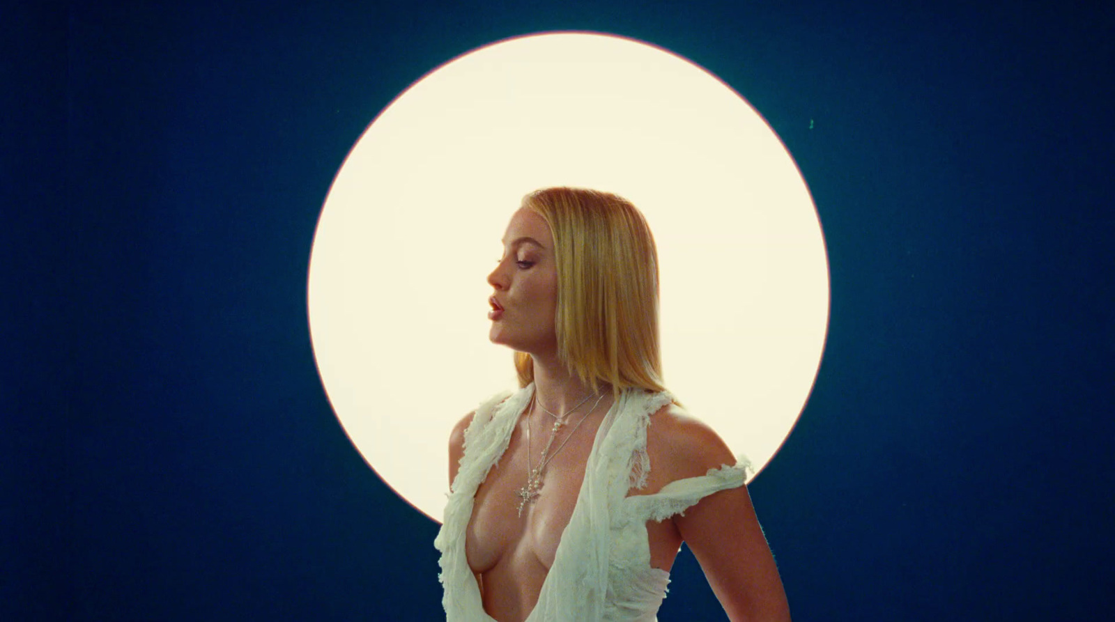 a woman in a white dress standing in front of a white circle