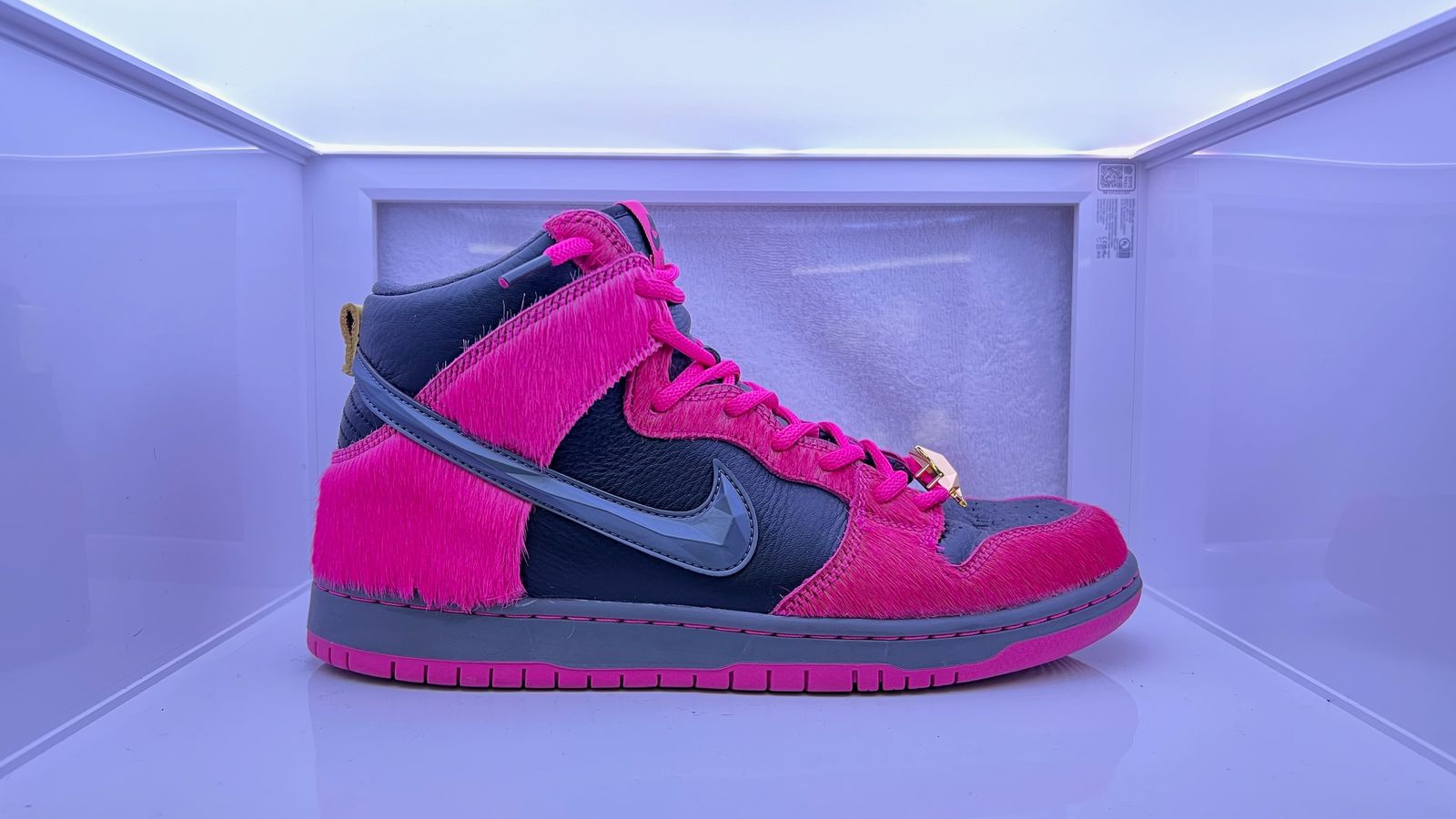 a pair of pink and blue sneakers in a display case