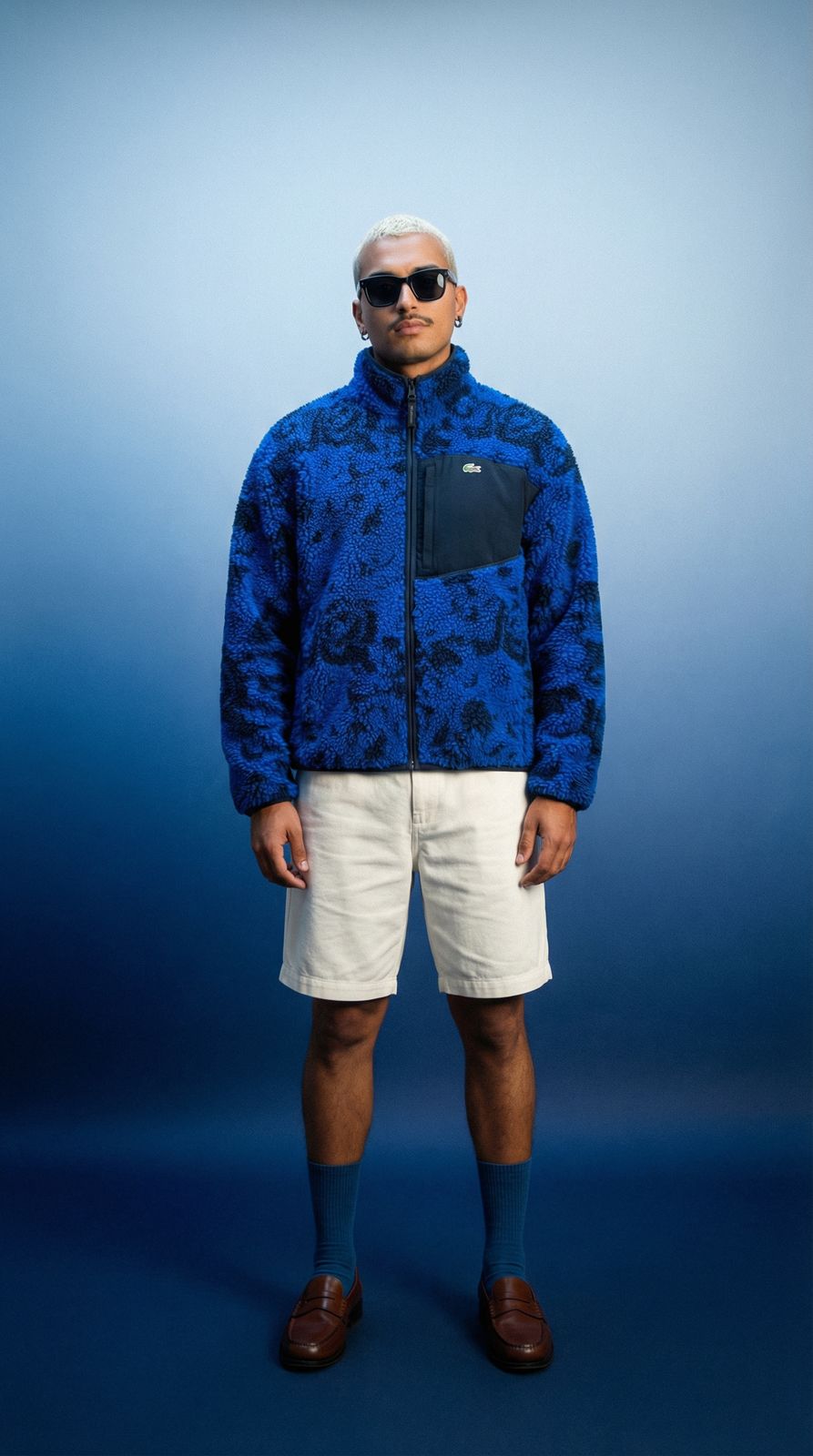 a man in a blue jacket and white shorts