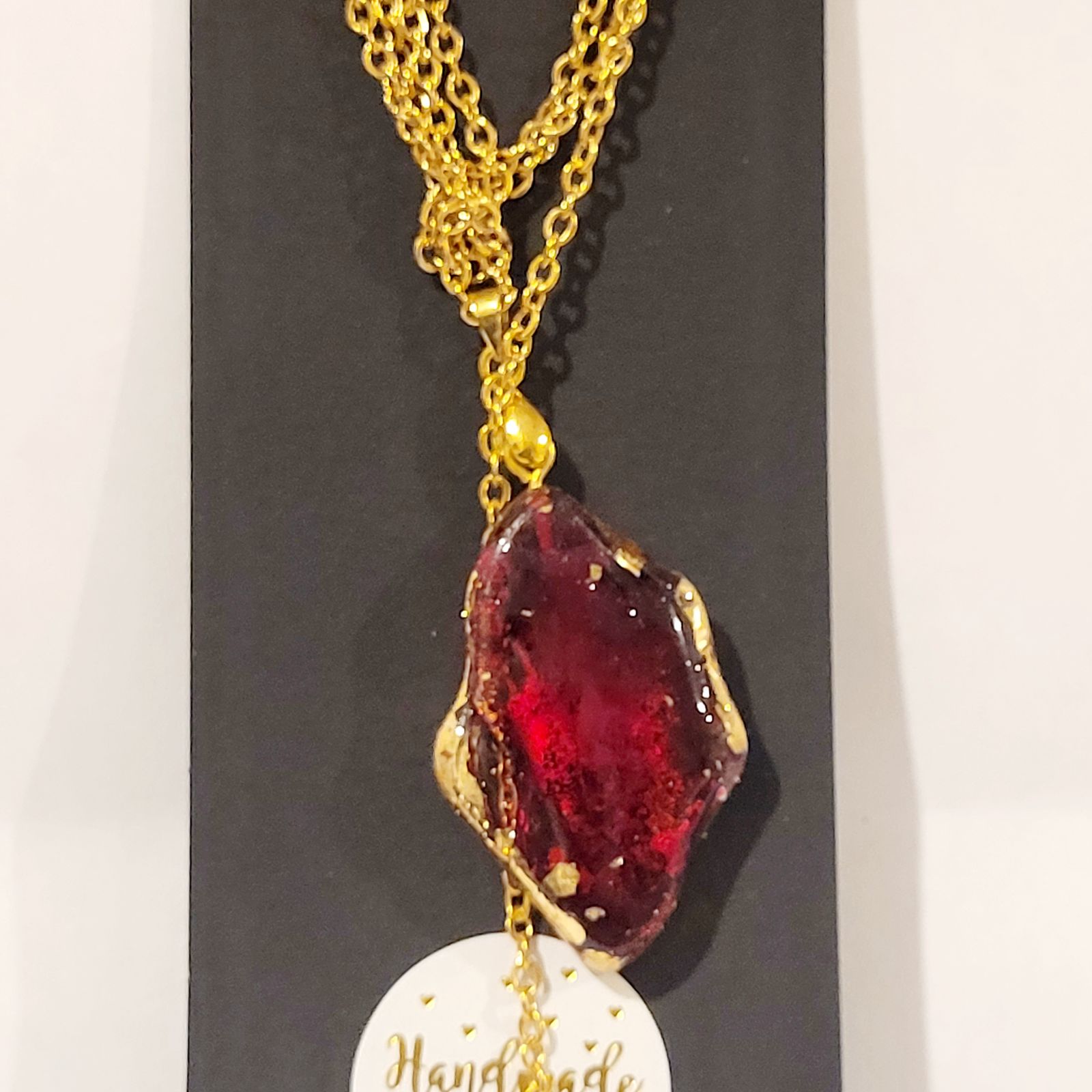 a necklace with a red piece of glass on it