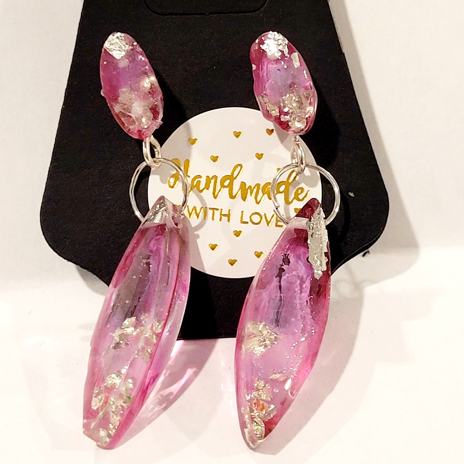 a pair of pink earrings sitting on top of a black box