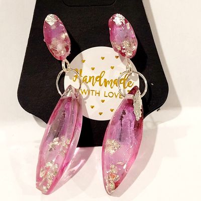 a pair of pink earrings sitting on top of a black box