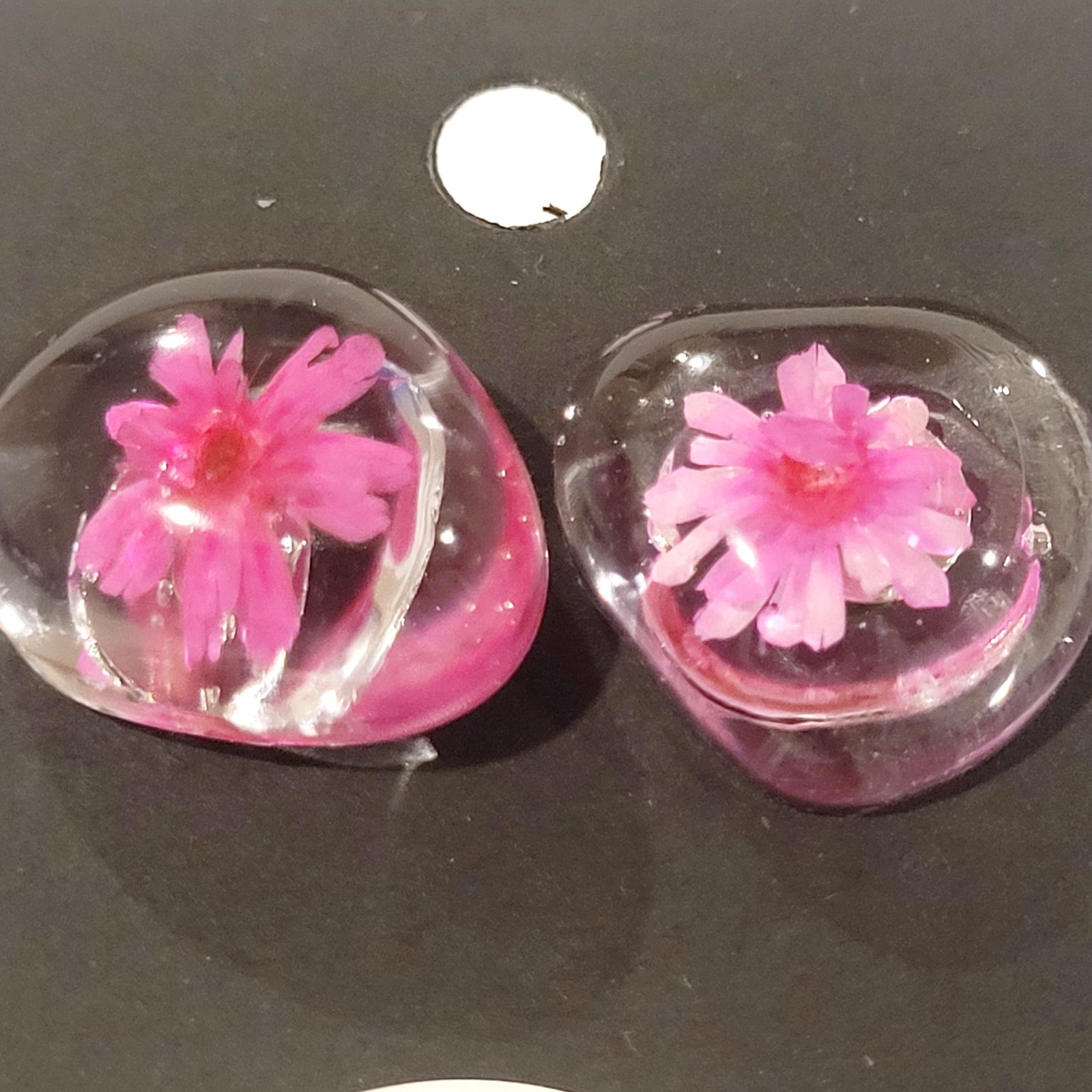 two glass vases with pink flowers inside of them
