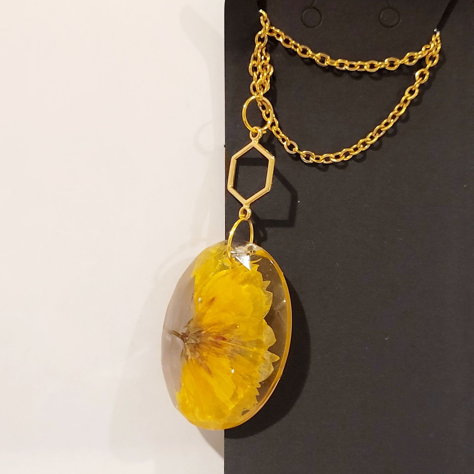 a yellow flower is hanging from a chain