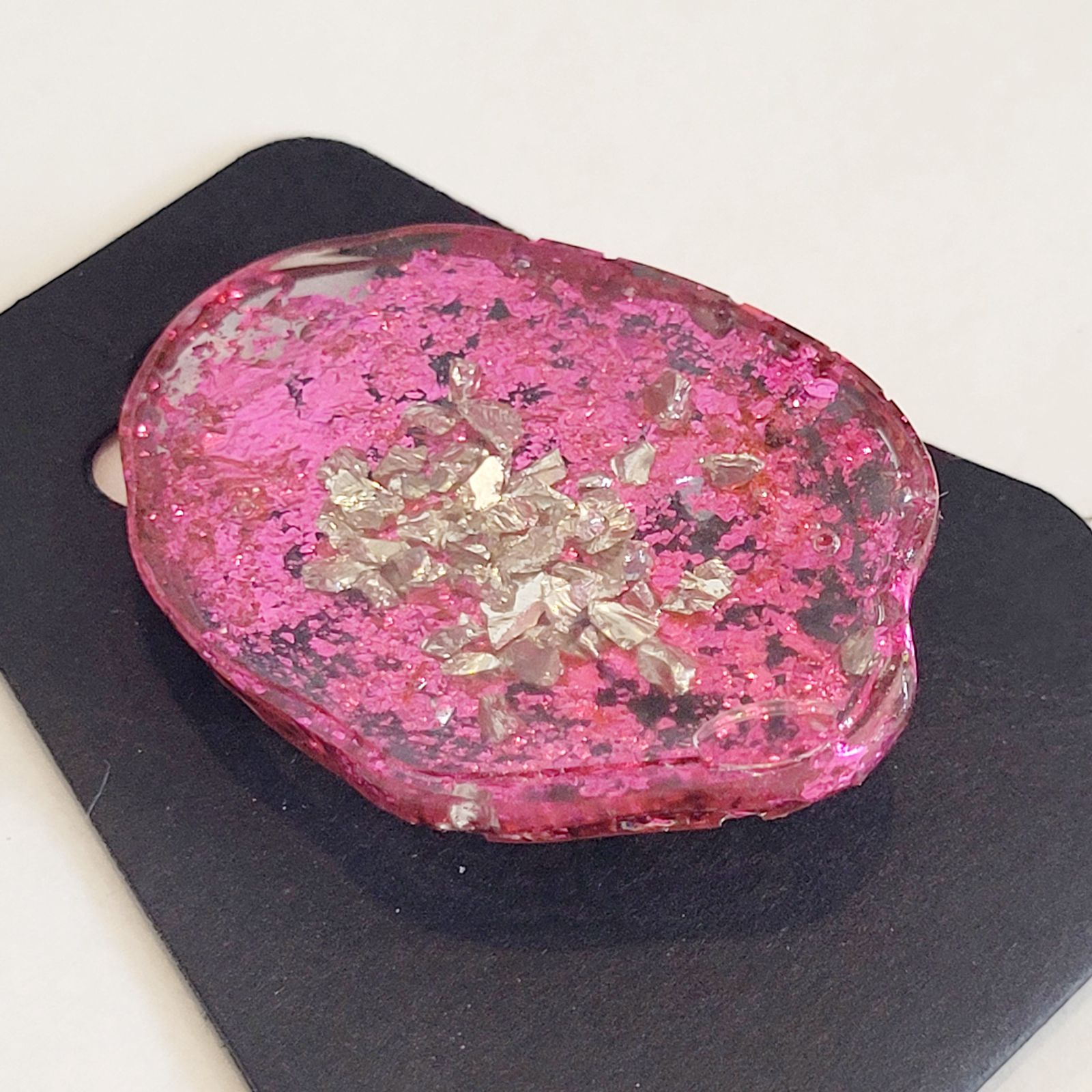 a pink rock sitting on top of a black plate