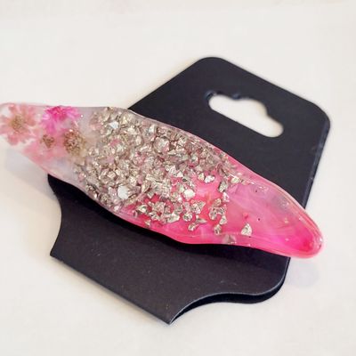 a pink and silver object sitting on top of a black holder
