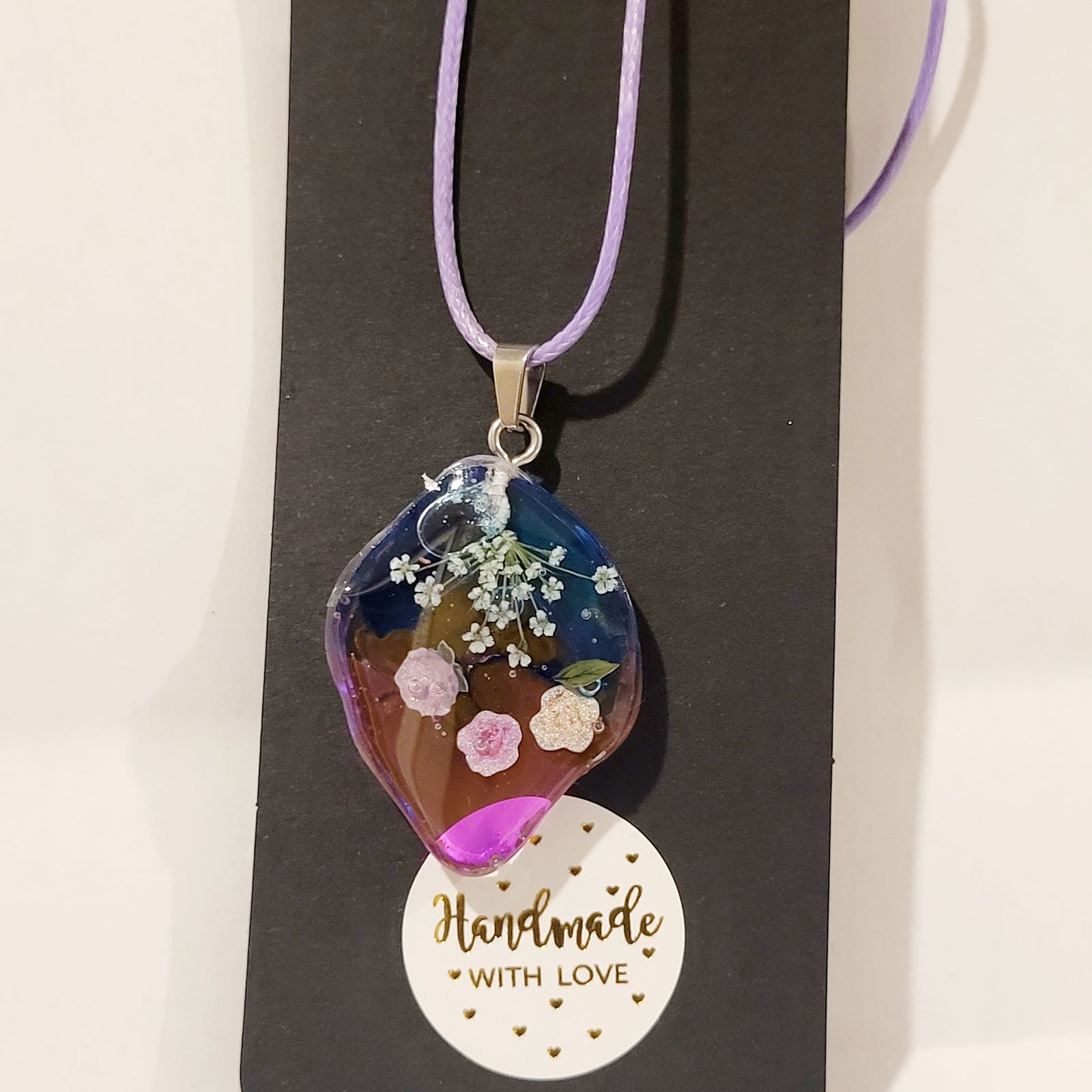 a necklace with flowers and a message on it