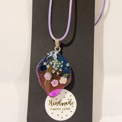 a necklace with flowers and a message on it