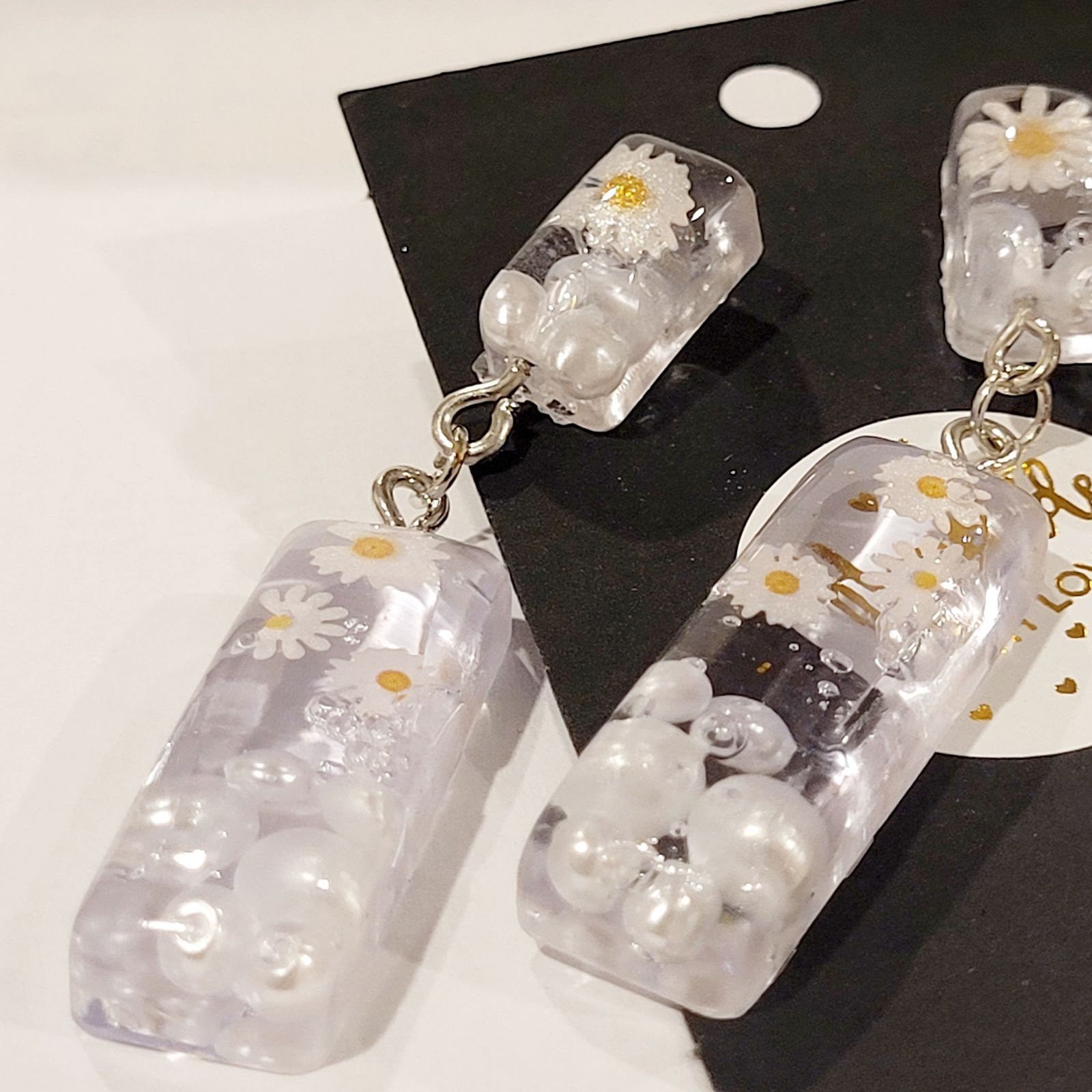 a pair of earrings with flowers on them