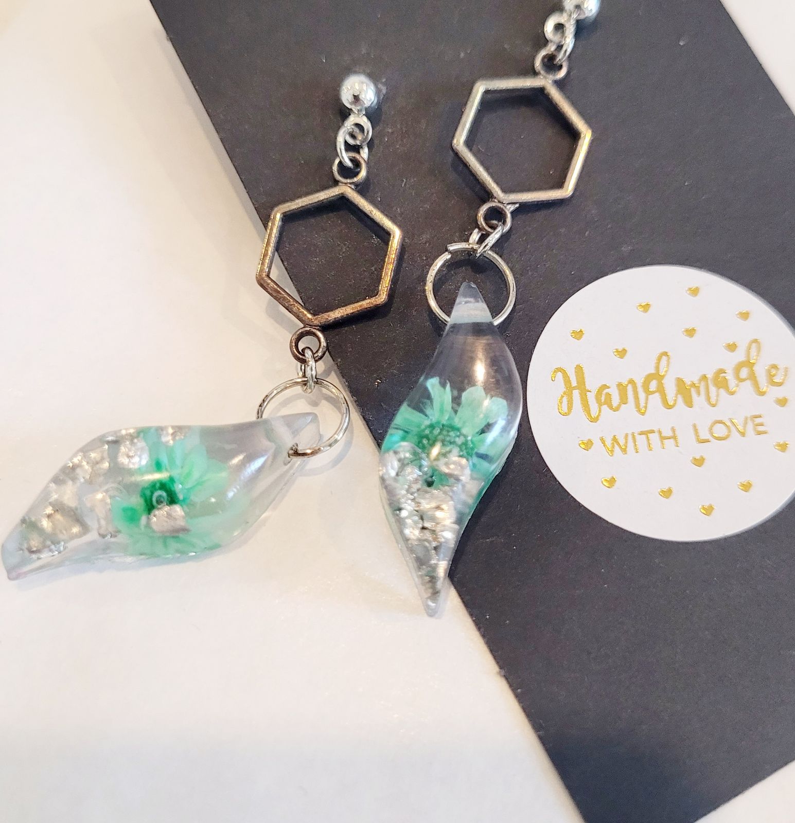 a pair of earrings sitting on top of a card