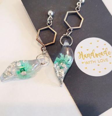 a pair of earrings sitting on top of a card