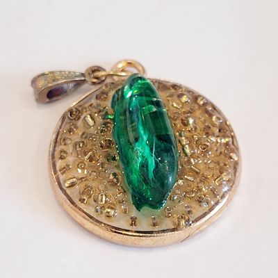 a pendant with a green stone on it
