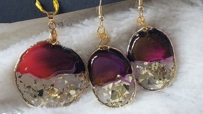 a pair of earrings that are on a white surface