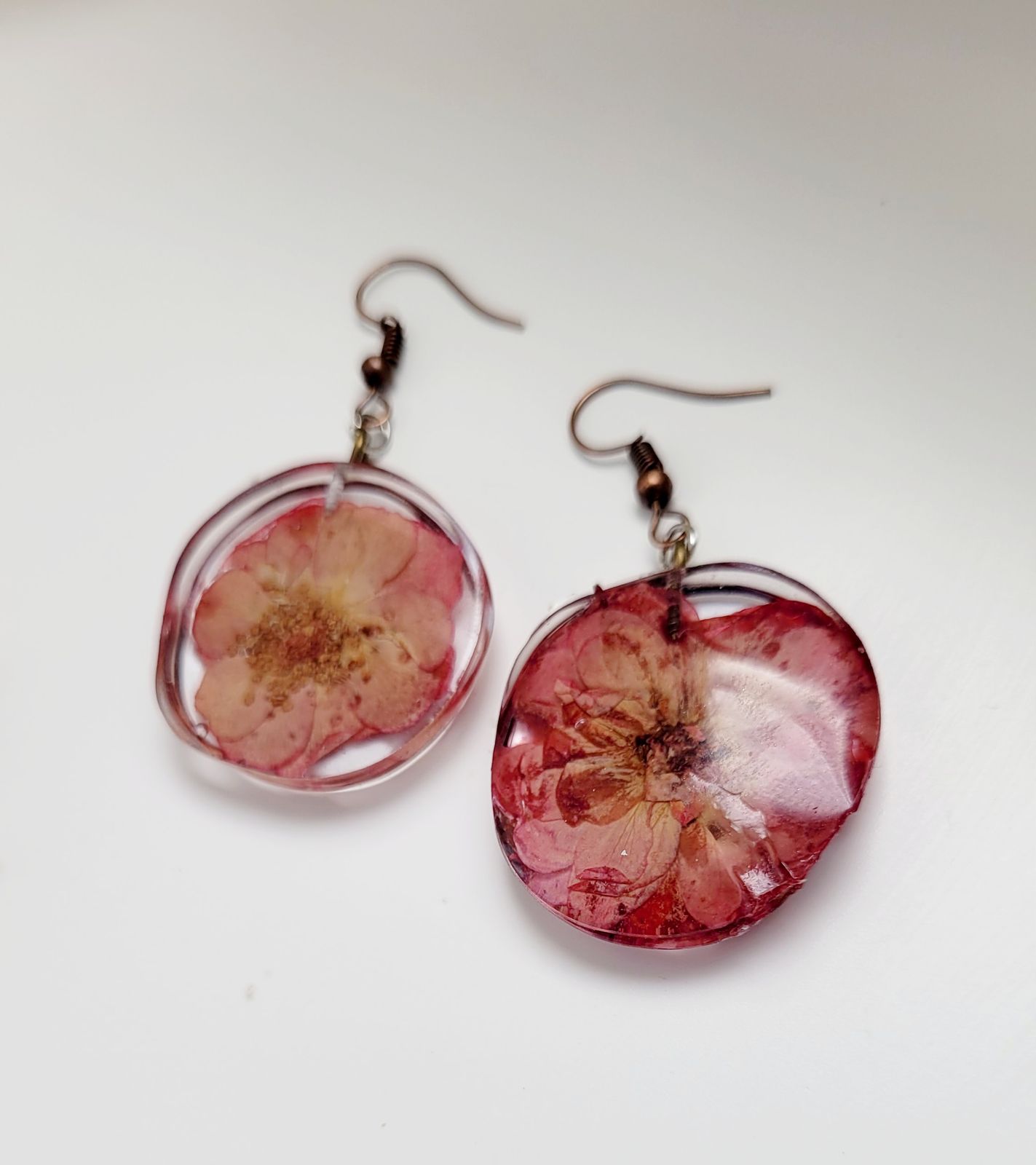 a pair of earrings with a flower on them