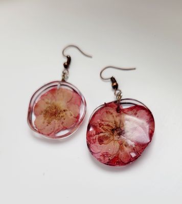 a pair of earrings with a flower on them