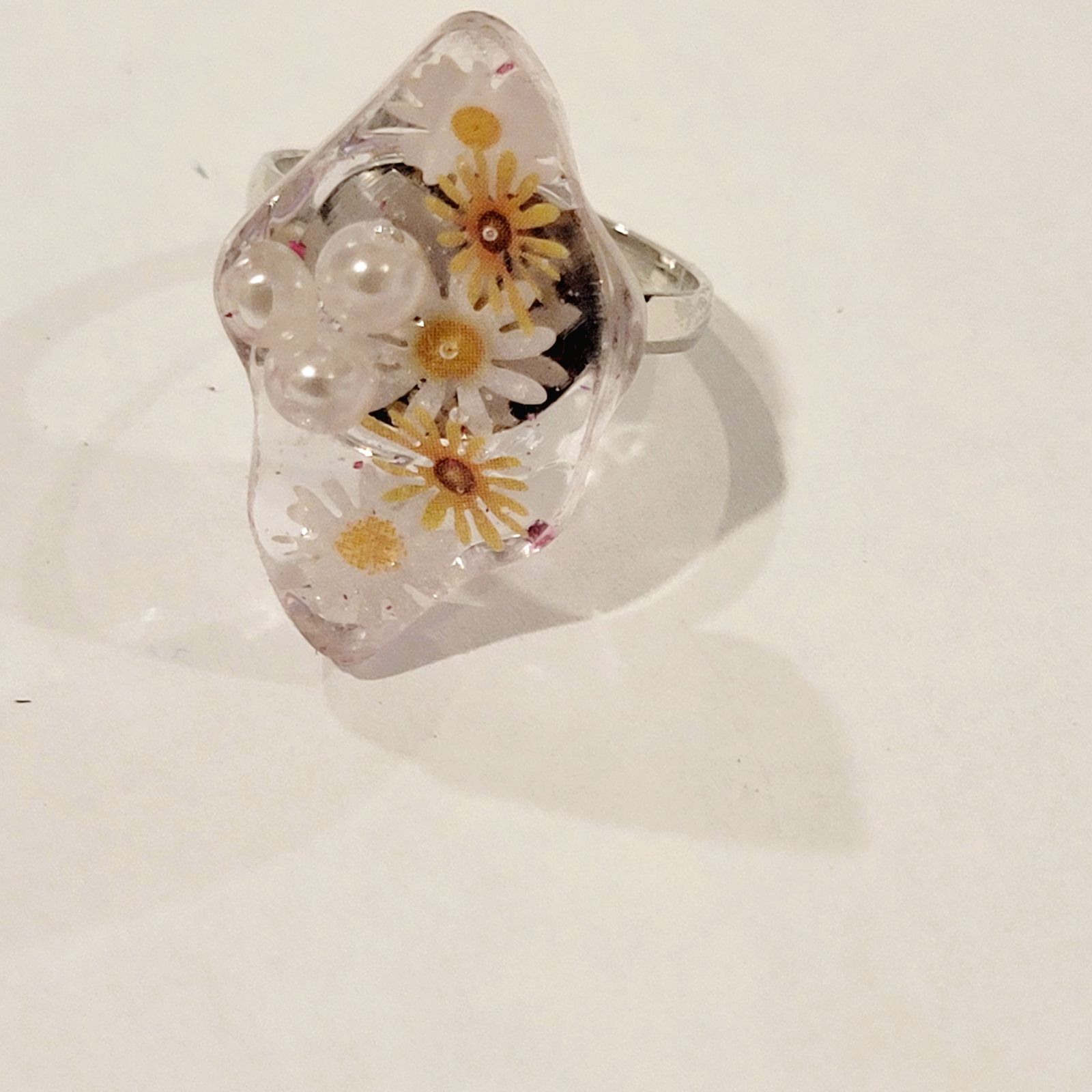 a glass ring with flowers and pearls on it