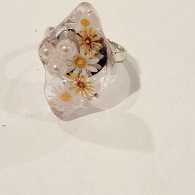 a glass ring with flowers and pearls on it