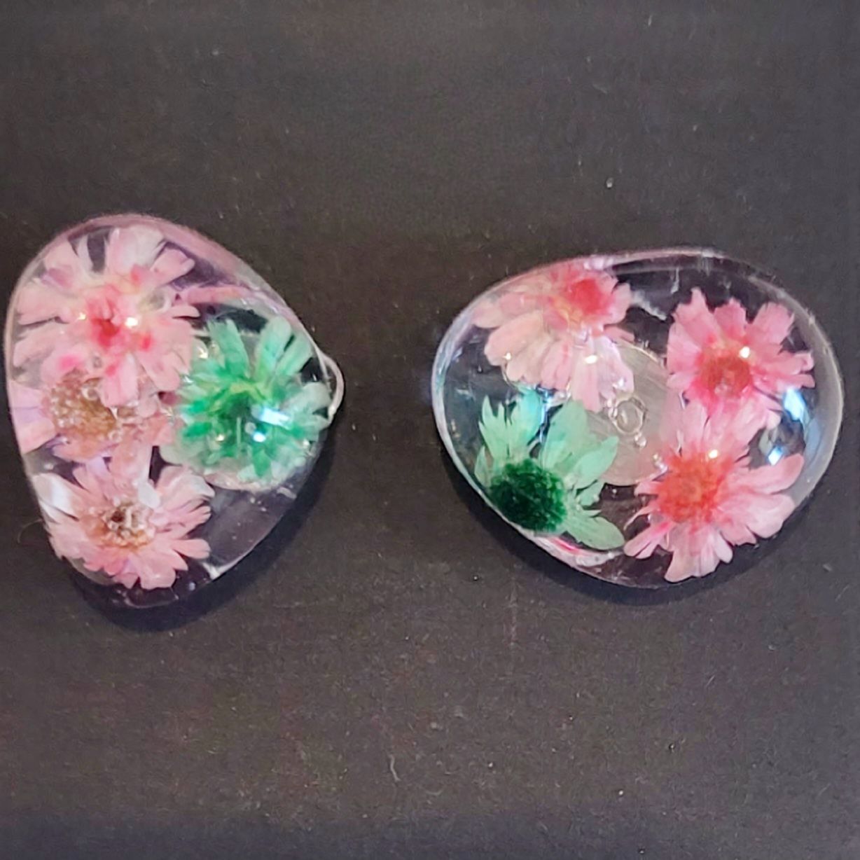 a pair of pink flowers sitting on top of a table