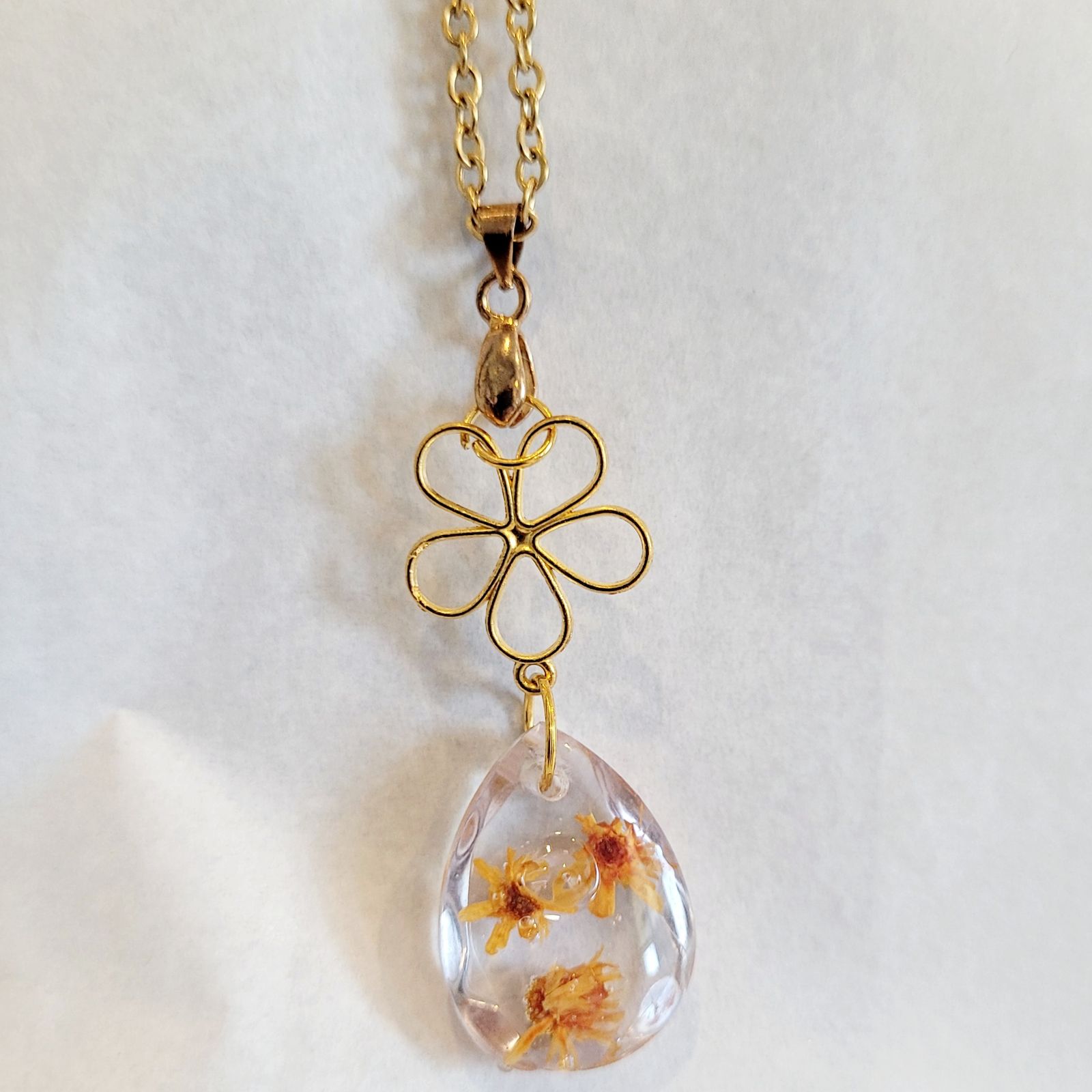 a gold chain with a glass pendant hanging from it