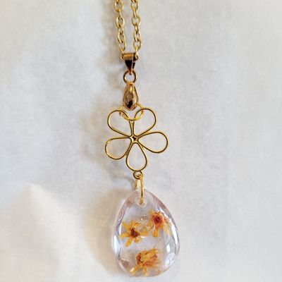 a gold chain with a glass pendant hanging from it