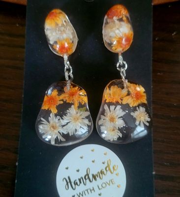 a pair of earrings with flowers on them