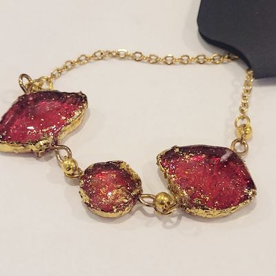 a gold bracelet with red stones on it