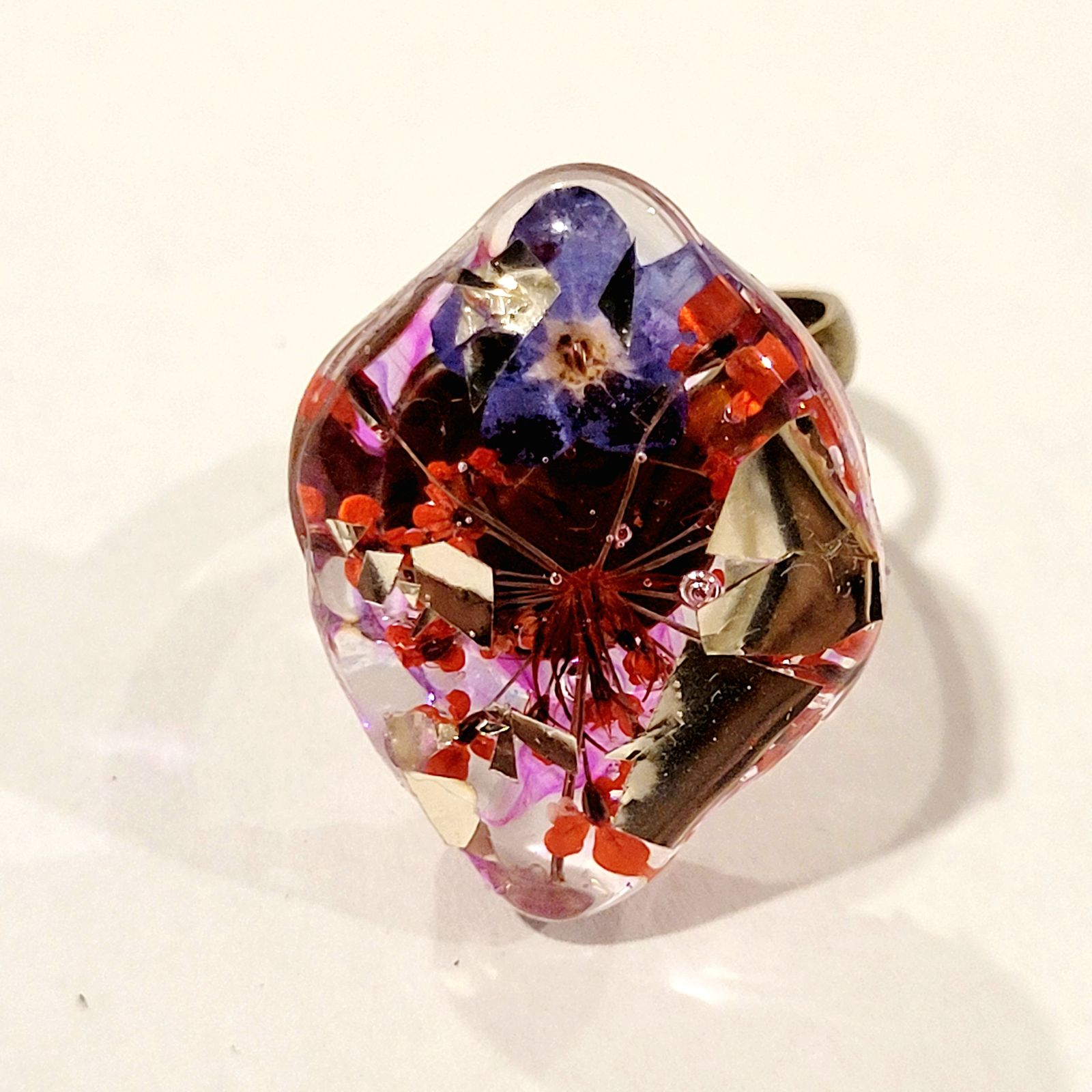 a glass ring with flowers in it on a white surface