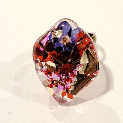a glass ring with flowers in it on a white surface