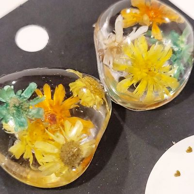 two glass vases with flowers inside of them
